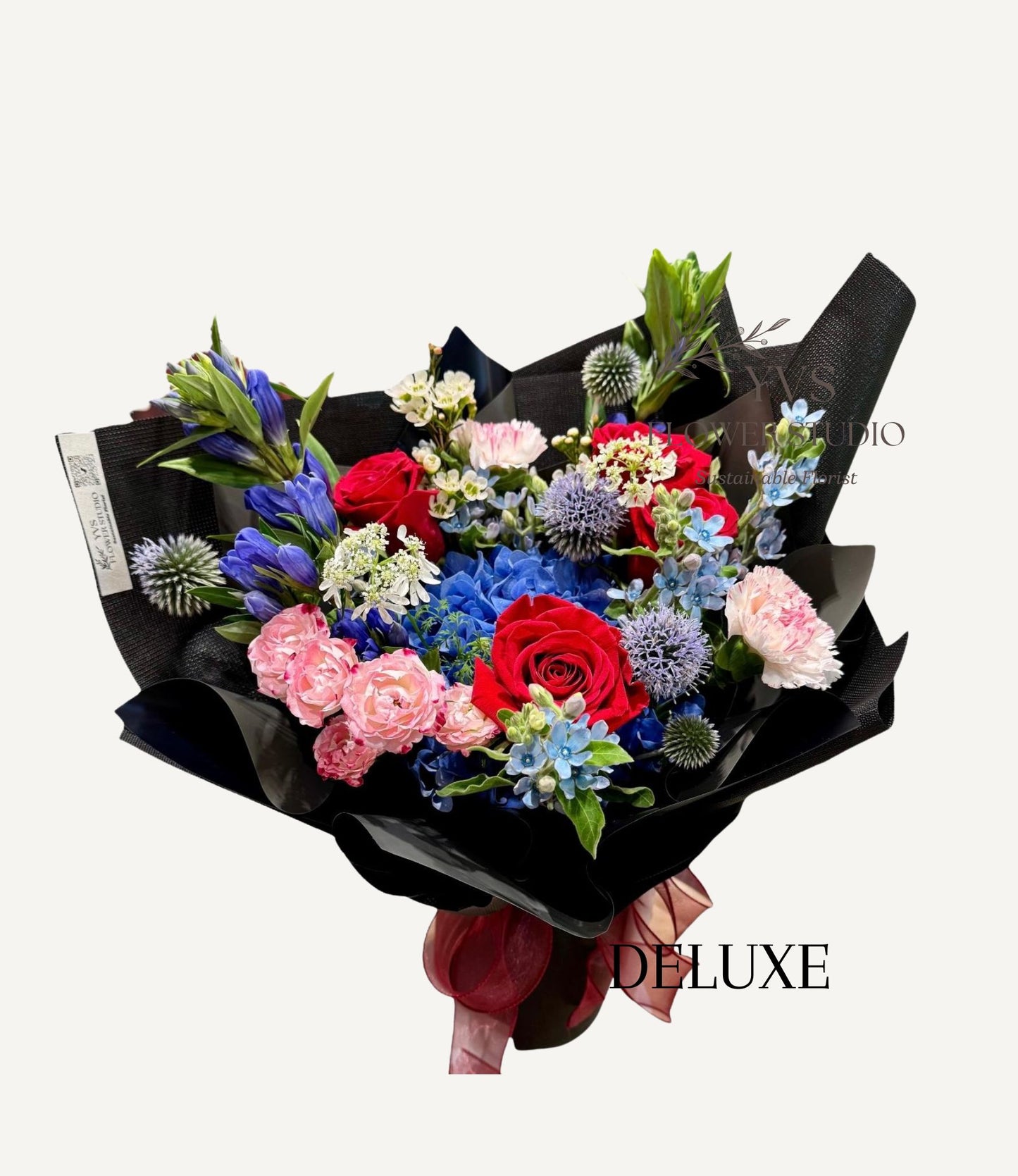 Bouquet of red and blue themed hydrangea bouquet wrapped in black paper