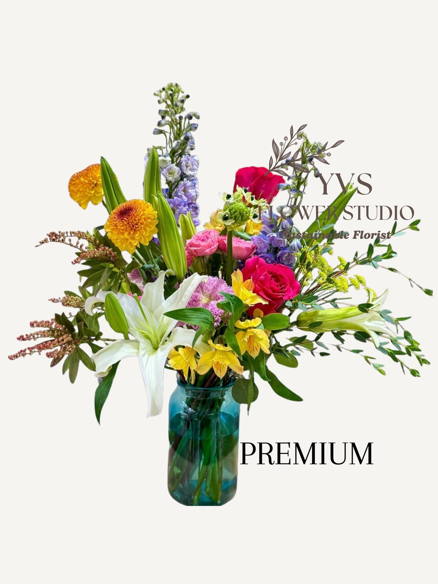 Colourful and vibrant flower arrangement in a vase with 'YVS Flower Studio' branding