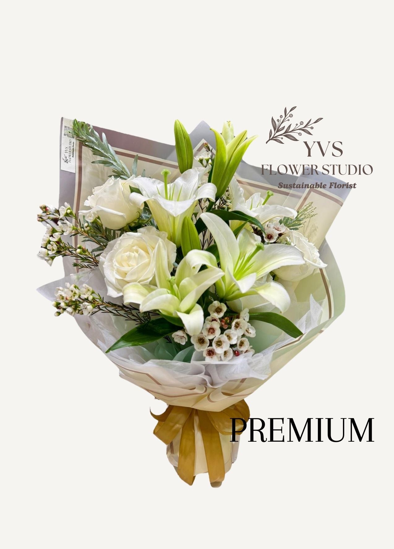 Bouquet of 2 stalks white lilies with roses and premium fillers, wrapped in paper and tied with a yellow ribbon, branded 'YVS Flower Studio'.