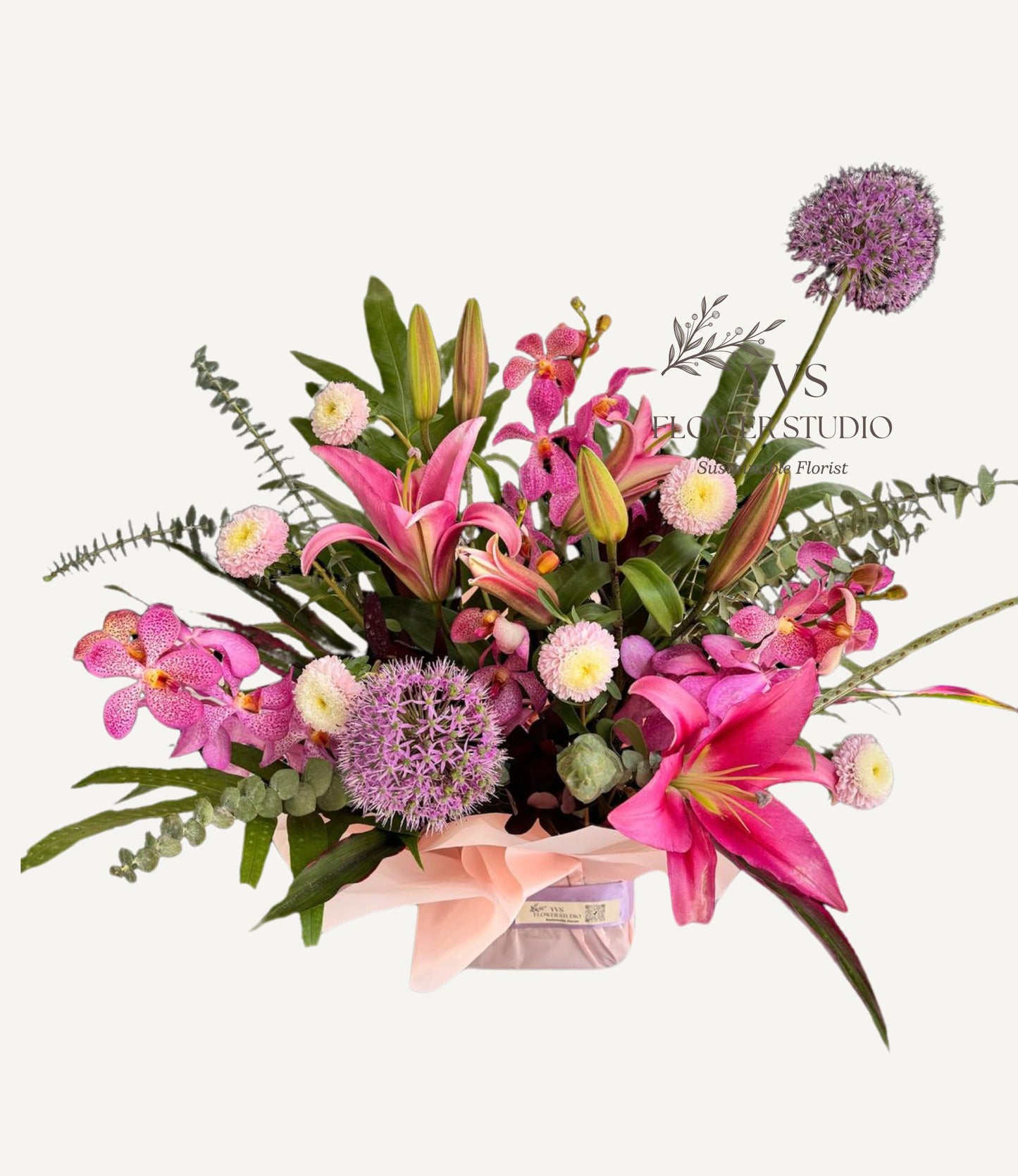 A table top arrangement consisting of a vibrant mix of pink and purple flowers and foliage