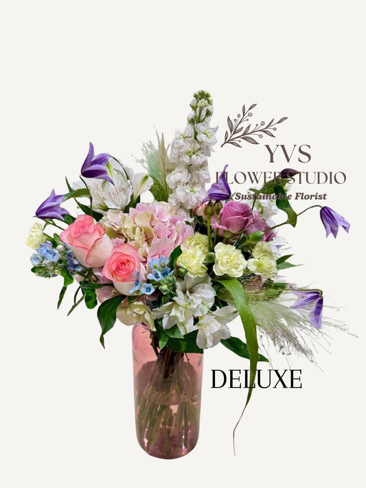 Bouquet of pastel themed flowers in a vase with YVS Flower Studio branding on a white background